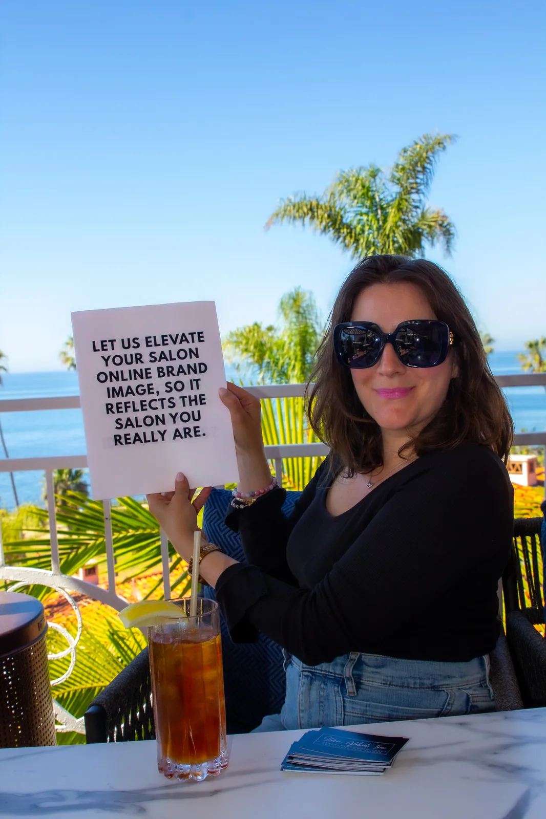 Rebekah holding a sign reading let us elevate your salon online brand image so it reflects the salon you really are