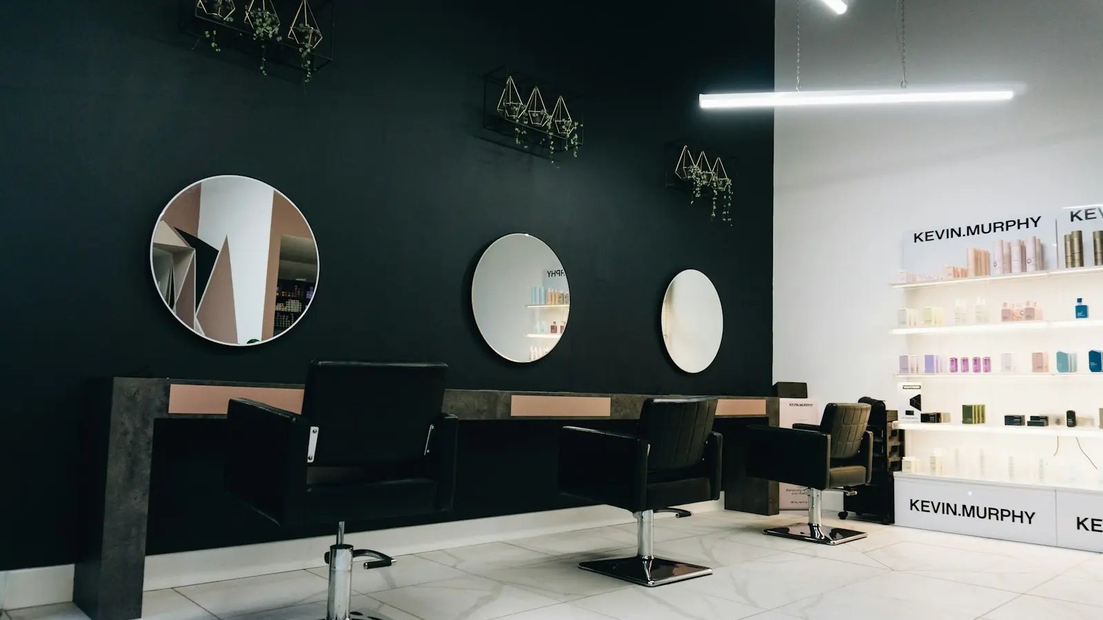 A bright white salon with mirrors and a styling station