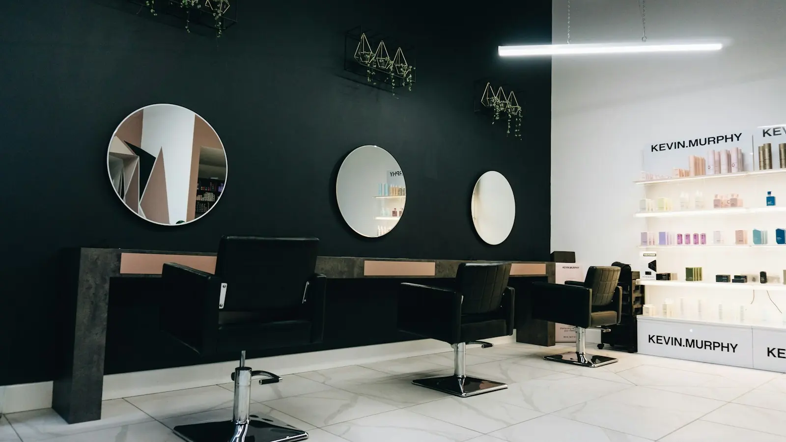 A clean empty salon with mirrors and a styling station