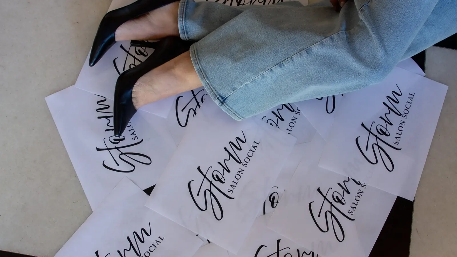 Storm Salon Social branded papers spread across a table