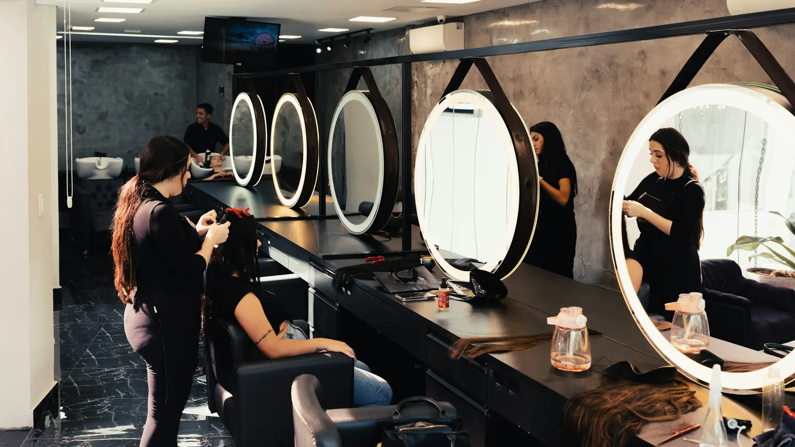 A salon styling station lit by a round mirror